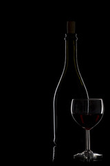 Bottle of wine and a glass of wine on a black background, minima