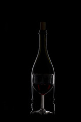 Bottle of wine and a glass of wine on a black background, minima