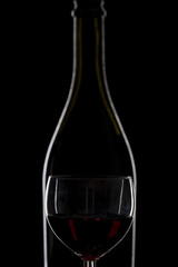 Bottle of wine and a glass of wine on a black background, minima