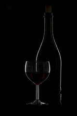 Bottle of wine and a glass of wine on a black background, minima