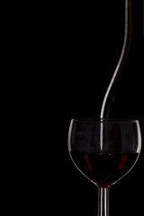 Obraz na płótnie Canvas Bottle of wine and a glass of wine on a black background, minima