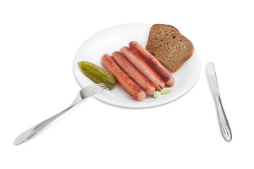 Grilled sausages, pickled cucumber and garlic, bread on white di