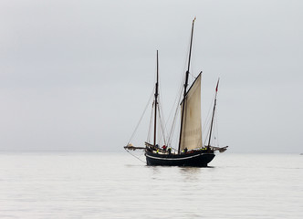 Ancient fishing boat, a Cornish lugger, becalmed off Newlyn, Cornwall, England, UK.