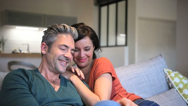 Middle-aged couple at home watching tv
