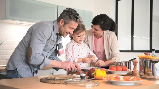 Parents with child cooking together at home