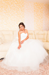 Beautiful bride in the interior sitting on couch