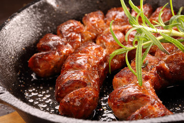 White sausage frying in a pan