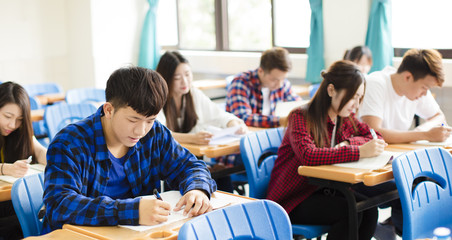 group of young students writing notes in the classroom