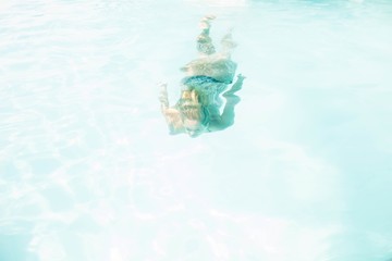 Obraz na płótnie Canvas Fit woman swimming under water