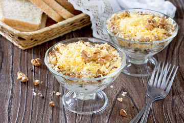 Salad with chicken, walnuts and cheese on a dark wooden table