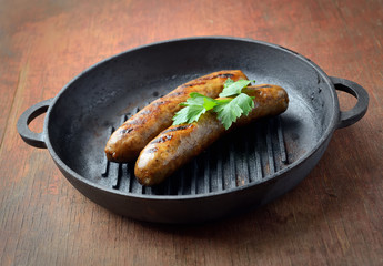 Two meat sausages in a pan
