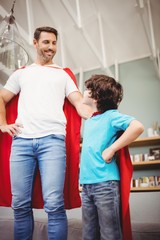 Obraz premium Cheerful father and son in superhero costume