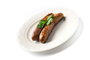 Two meat sausages on a plate on a white background