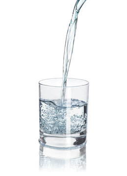 pour water into the half-full glass with reflection isolated on