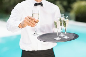 Midsection of waiter offering champagne