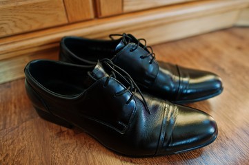 black bridegroom shoes at wooden parquet