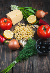 Ingredients for pasta, vegetables on an old table. top view