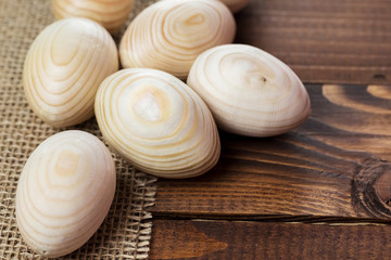 Beautiful wooden Easter eggs lying on the sacking and old brown boards, with free space for your text