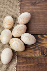 Beautiful wooden Easter eggs lying on the sacking and old brown boards, with free space for your text