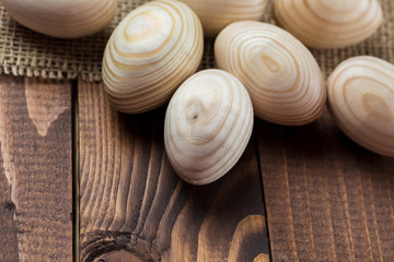 Beautiful wooden Easter eggs lying on the sacking and old brown boards, with free space for your text