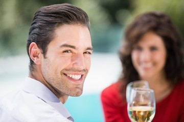 Portrait of young man toasting white wine 