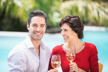Cheerful couple holding white wine 