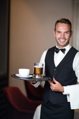 Waiter holding tray with beer