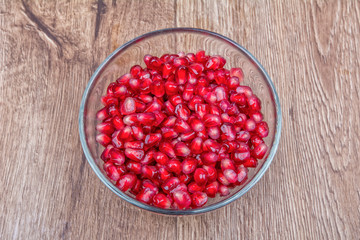 Fresh organic pomegranate seeds in a bowl on a background