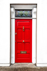 Red door with golden door handle and mailbox slot