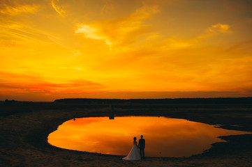 Naklejka na ściany i meble wedding couple on the background of sunset