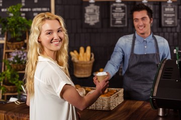 Smiling waiter serving a coffee to a customer