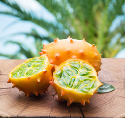 Kiwano fruits on the wooden table with green nature on the backg