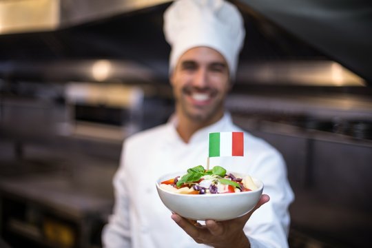 Handsome chef presenting meal with italian flag