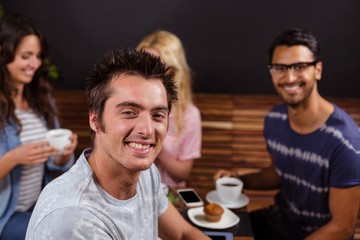 Smiling friends enjoying coffee together