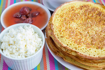 Pancakes with strawberry jam, cheese and a cup of tea