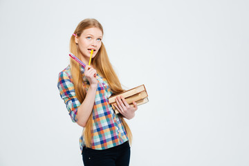 Pensive female student standing with books