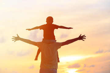 Obraz na płótnie Canvas father and son play on sunset sky