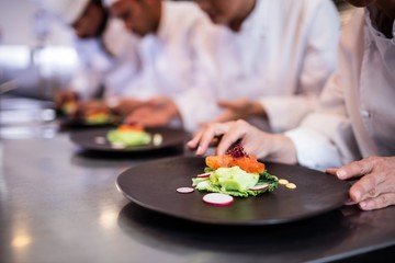 Close-up of chef decorating food plate