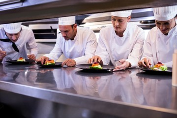 Fototapeta na wymiar Team of chefs garnishing dishes