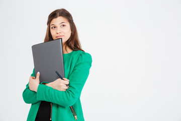 Thoughtful attractive woman in green jacket holding folders and thinking