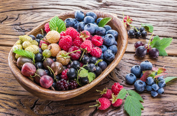 Ripe berries in the wooden bowl.
