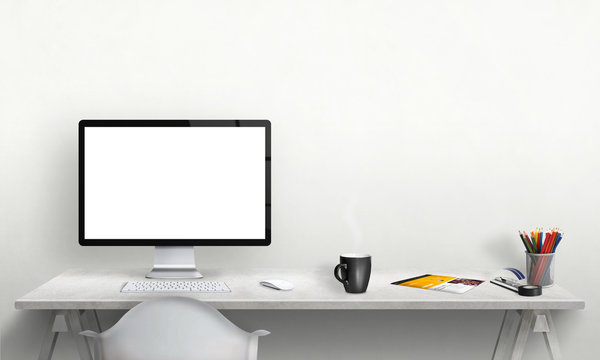 Isolated computer display for mockup in office interior. Work desk with keyboard, mouse, cup of coffee, paper, pencils. Free space on wall for text.