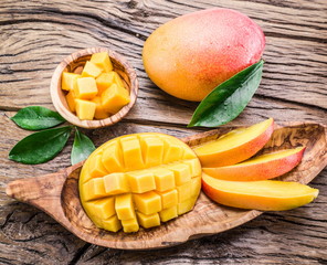 Mango fruit and mango cubes on the wooden table.