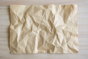 Blank crumpled paper on wooden background