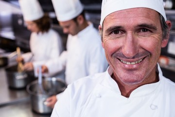 Fototapeta na wymiar Portrait of smiling chef in commercial kitchen