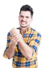 Fototapeta premium Portrait of angry young man with pain in his wrist