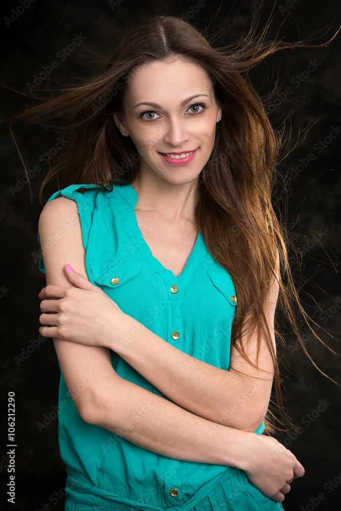 Wall mural young brunette woman with long flying hair