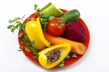 bright vegetables on a plate top view on a white background