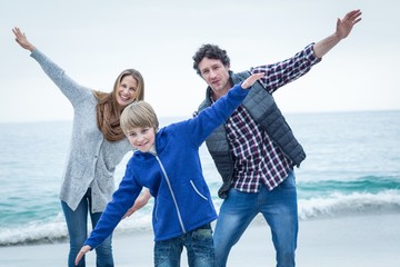 Fototapeta na wymiar Family enjoying at sea shore against sky