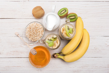 Smoothies with oatmeal, banana, kiwi in glass jars .